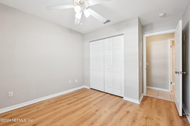 unfurnished bedroom featuring a closet, light wood-type flooring, and ceiling fan