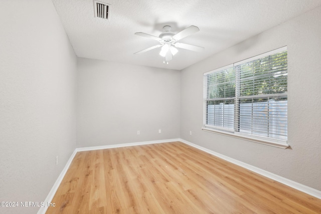 unfurnished room with light hardwood / wood-style floors, a textured ceiling, and ceiling fan