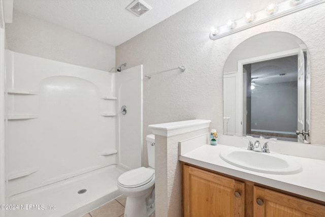 bathroom featuring a textured ceiling, a shower, toilet, vanity, and tile patterned floors