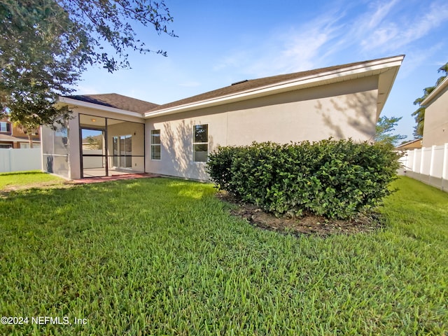 rear view of property featuring a lawn