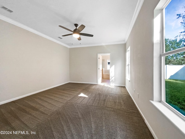 carpeted spare room featuring ceiling fan, plenty of natural light, and crown molding