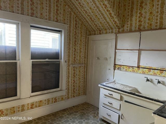 kitchen with vaulted ceiling and white cabinets