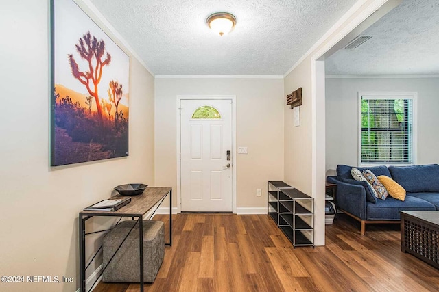 foyer entrance with a textured ceiling, hardwood / wood-style floors, and crown molding