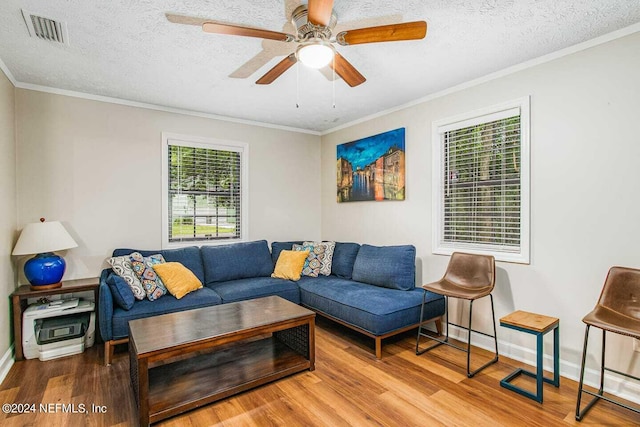 living room with a textured ceiling, ceiling fan, and hardwood / wood-style flooring