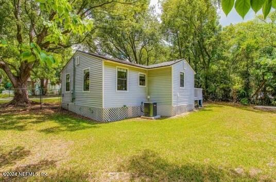 back of property featuring a yard and central AC unit