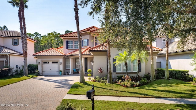 mediterranean / spanish-style home with a front yard and a garage