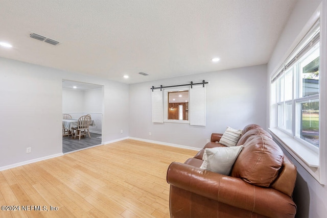 living area featuring a barn door and wood-type flooring