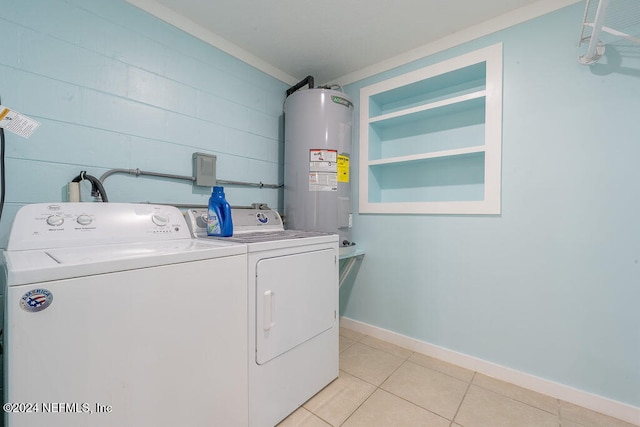 clothes washing area featuring washing machine and clothes dryer, light tile patterned floors, and electric water heater