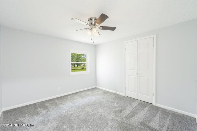 spare room with carpet floors and ceiling fan