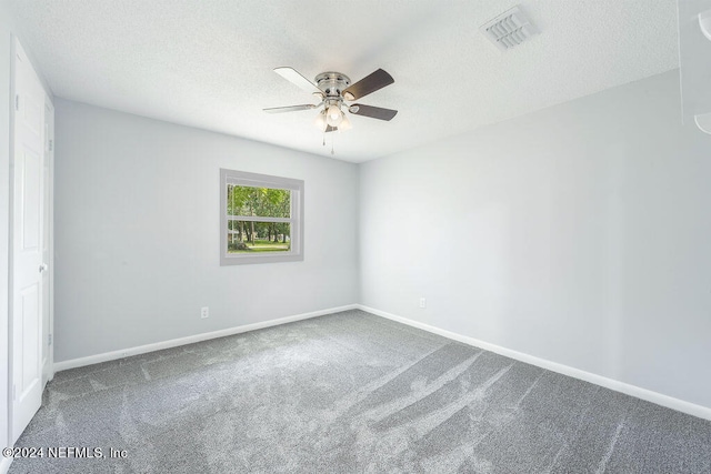 carpeted empty room featuring ceiling fan and a textured ceiling