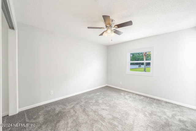 empty room featuring ceiling fan, a textured ceiling, and carpet