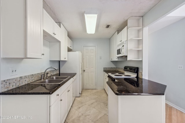 2696 Forest Ridge Dr Unit A-6, Fernandina Beach, FL 32034 - kitchen with open shelves, white appliances, white cabinets, a peninsula, and tasteful backsplash