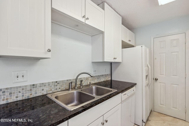 kitchen with a textured ceiling, tasteful backsplash, sink, white cabinets, and white dishwasher