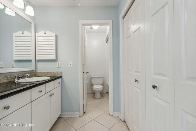 bathroom with vanity, tile patterned flooring, and toilet