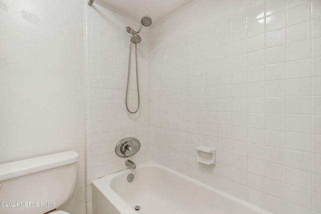 bathroom with tiled shower / bath and toilet