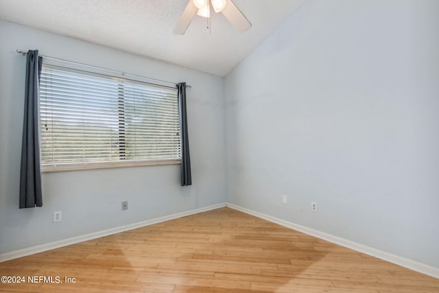 spare room featuring a textured ceiling, lofted ceiling, ceiling fan, and light hardwood / wood-style flooring