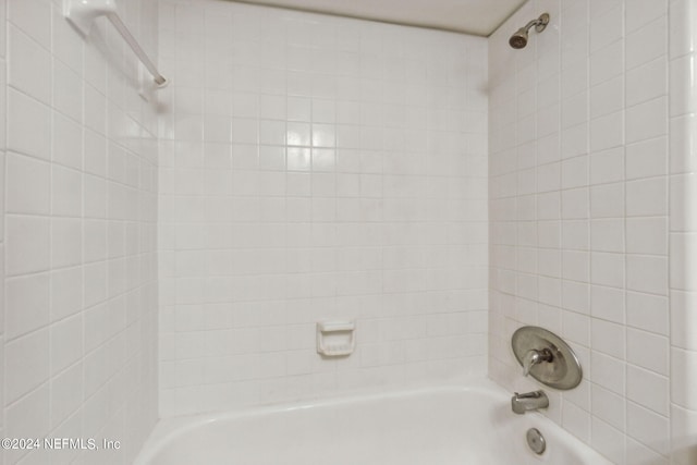 interior details with tiled shower / bath combo