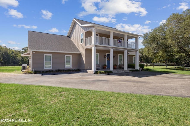 view of front of property with a front yard, a porch, and a balcony