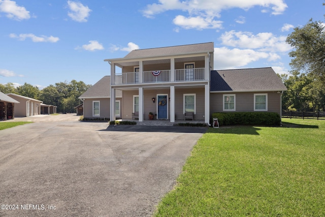 view of front of house with a front yard, a porch, and a balcony