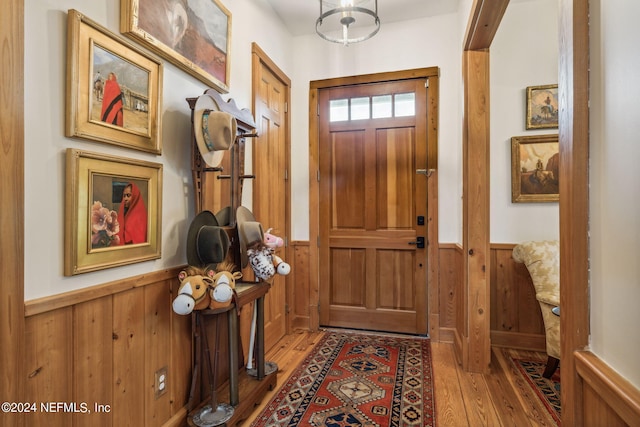 doorway to outside featuring wooden walls and light wood-type flooring