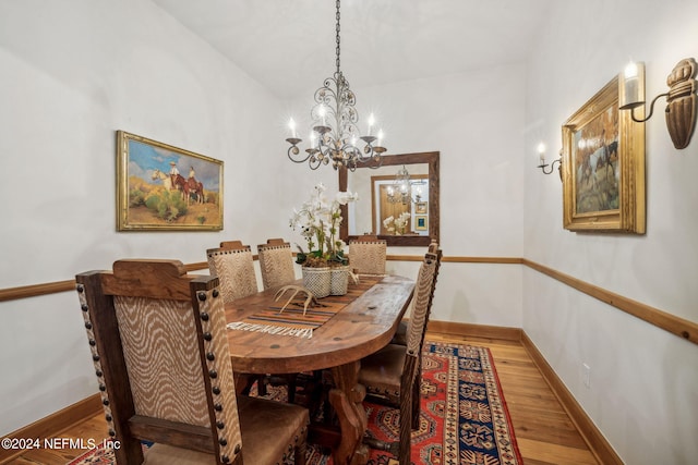 dining area featuring hardwood / wood-style floors and a notable chandelier