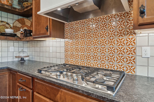 kitchen with wall chimney exhaust hood, stainless steel gas cooktop, and tasteful backsplash