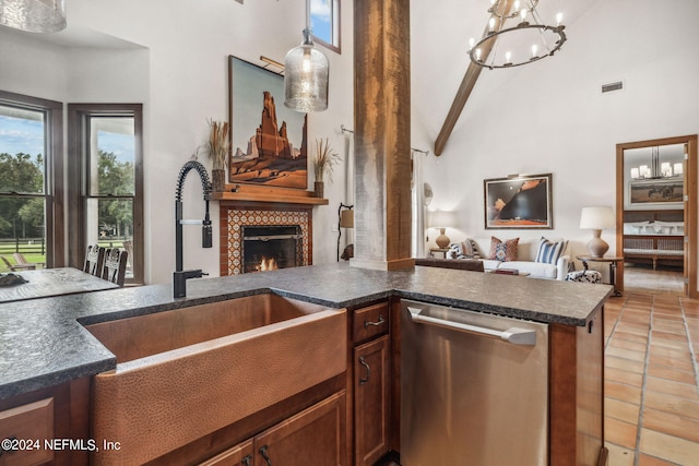 kitchen with dishwasher, a tiled fireplace, sink, and a wealth of natural light