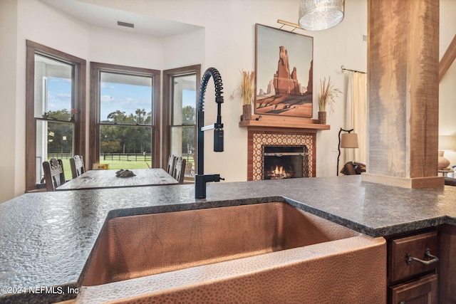 kitchen featuring a fireplace, sink, and dark brown cabinets