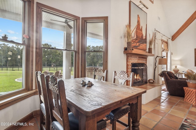 dining room with light tile patterned flooring, high vaulted ceiling, a wealth of natural light, and ceiling fan