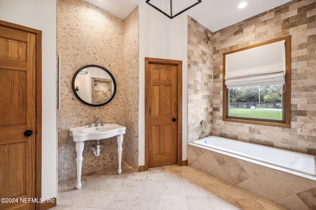 bathroom featuring tiled tub and tile walls