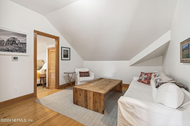 living room with vaulted ceiling and hardwood / wood-style flooring