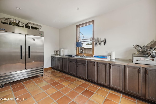 kitchen featuring dark brown cabinetry, tile patterned floors, and built in fridge