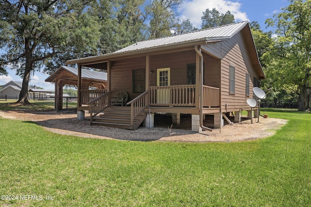 rear view of property featuring a lawn