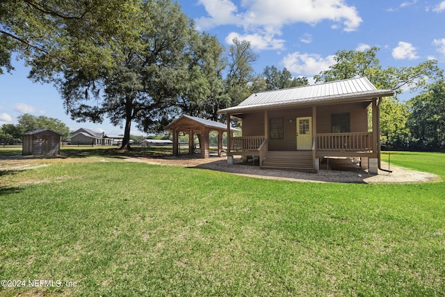 back of property with a porch, a yard, and a storage unit