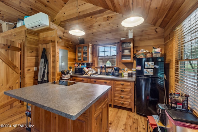 kitchen with lofted ceiling, black appliances, a center island, sink, and light hardwood / wood-style flooring