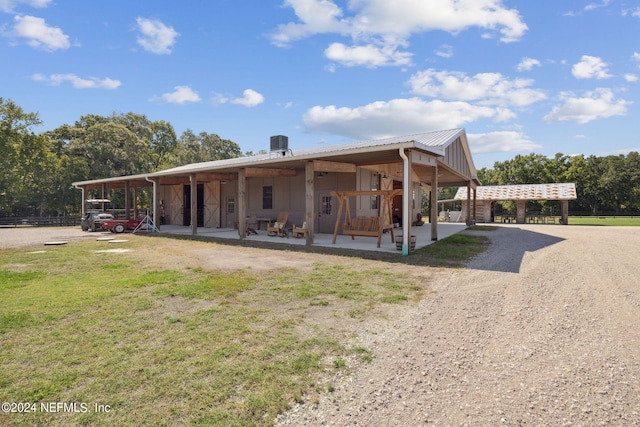 view of front of home with a carport, a front yard, and a patio area