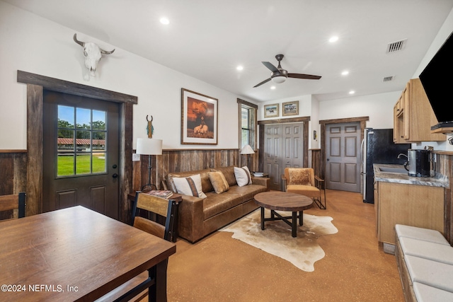 living room with wooden walls and ceiling fan