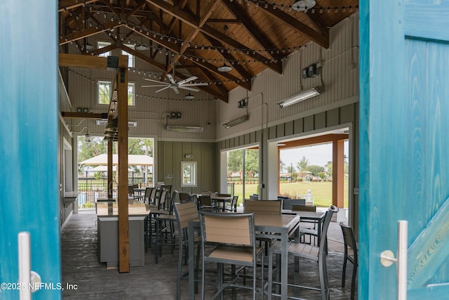 dining area featuring beam ceiling and high vaulted ceiling