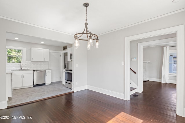 interior space featuring ornamental molding, a chandelier, light hardwood / wood-style floors, and sink