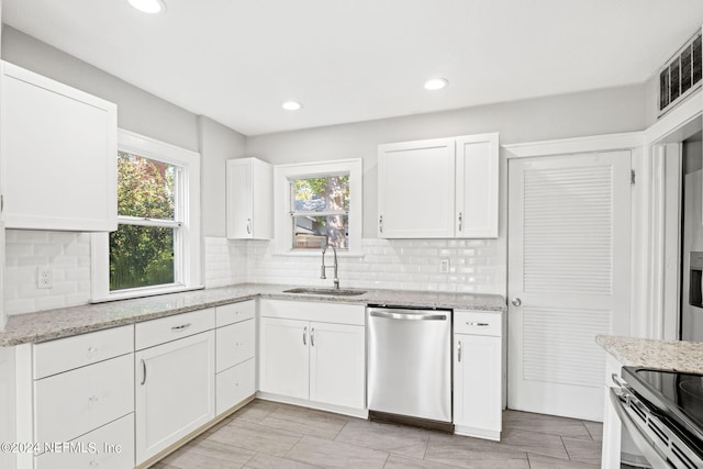 kitchen featuring appliances with stainless steel finishes, plenty of natural light, sink, and white cabinetry