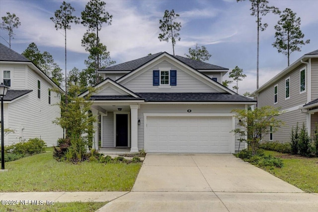 view of front of home with a garage and a front lawn