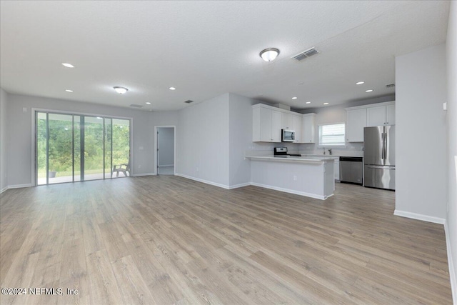 unfurnished living room featuring light hardwood / wood-style floors and sink