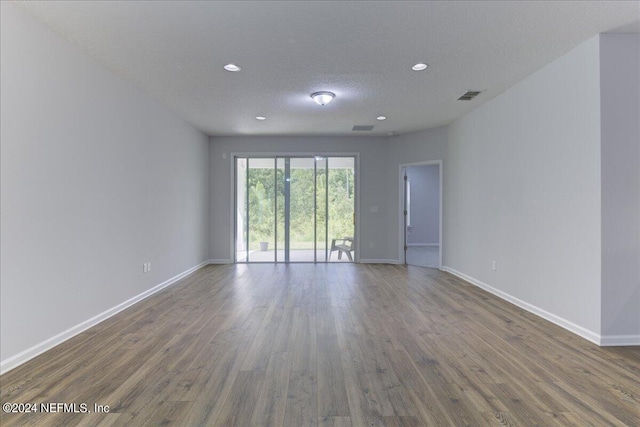 empty room featuring a textured ceiling and hardwood / wood-style floors