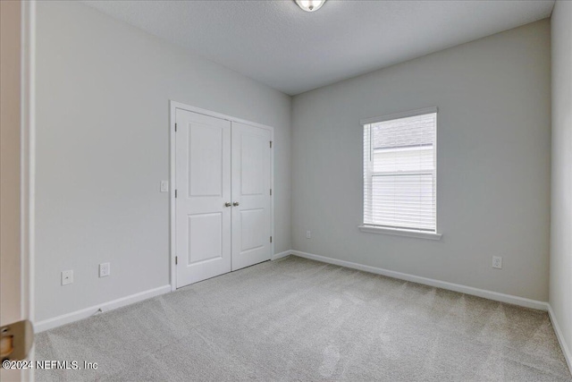 unfurnished room featuring light carpet