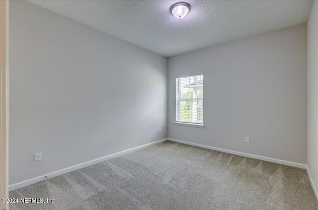 unfurnished room featuring carpet floors and a textured ceiling