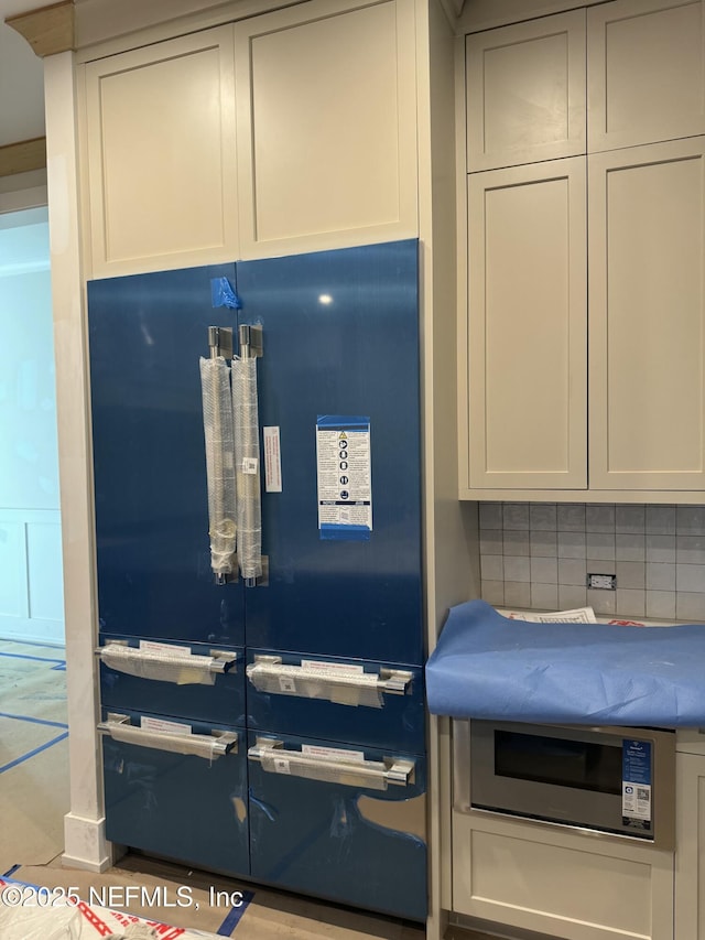 kitchen with paneled built in refrigerator and decorative backsplash