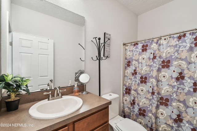 bathroom featuring a textured ceiling, vanity, and toilet