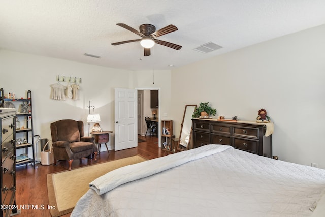 bedroom with a textured ceiling, ceiling fan, and dark wood-type flooring