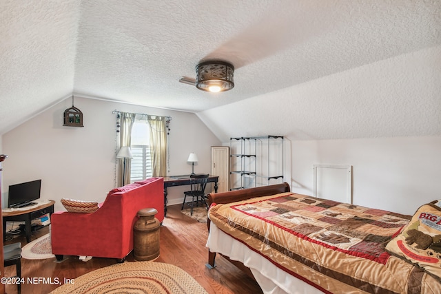 bedroom with hardwood / wood-style floors, ceiling fan, a textured ceiling, and vaulted ceiling