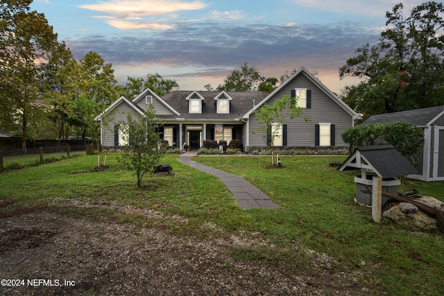 view of front of property with a lawn and a storage shed